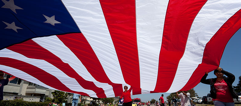 A huge US flag is held aloft by a small team during the annual Channel Islands Harbot 10l & 5k Fun Run/Walk