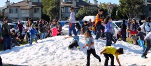 Kids play in piles of freshly made 'snow' at the Holiday Marketplace