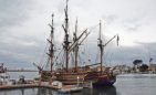 A pair of tall ships is docked at the harbor, one is the Hawaiian Chieftain