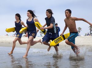 4 teens race to the water carrying buoys
