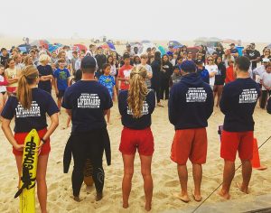 A group of Ventura Junior Lifeguard instructors speaks to a small crowd of hopefuls