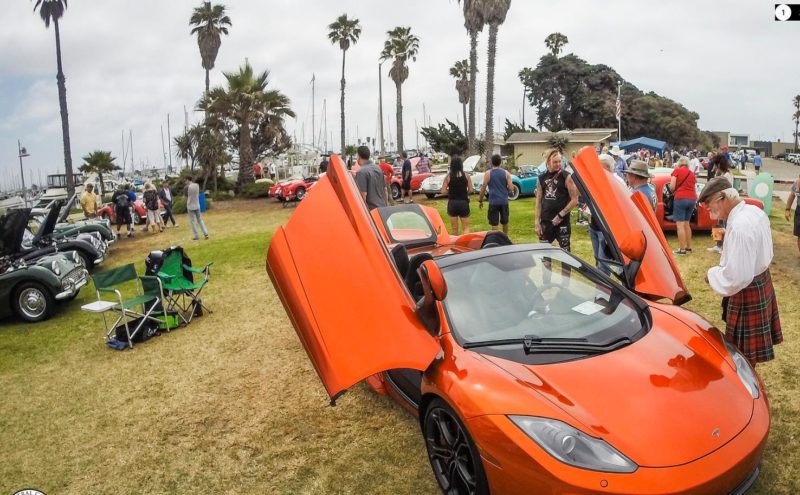 A sporty orange Tesla with its doors raised at the Central Coast British Car Club show