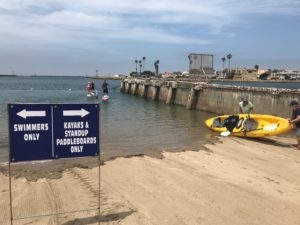 A pair of paddlers lift their kayak into the water