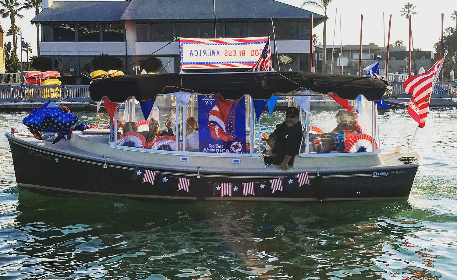 A Duffy boat decorated in red-white-and-blue for the Electric Boat Parade on the 4th of July