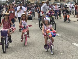 Children ride their bikes in colorful costumes for the 4th of July Children's Parade