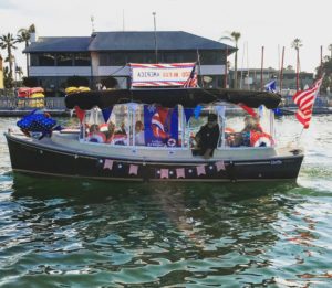 4th of July celebrants crowd a flag-decorated duffy electric boat in the harbor