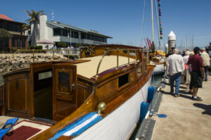 A classic wooden boat, white with laquered cherry trim, pictured outside CIMM