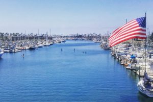 Wide view of the harbour, a large American flag flapping in the foreground