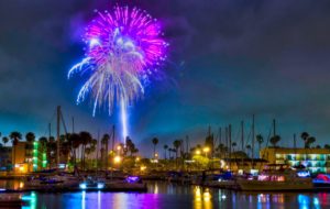 Purple and blue light spills from fireworks over Channel Islands Harbor