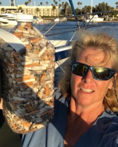Gallons of cigarette butts held aloft by a Coastal Cleanup Day participant