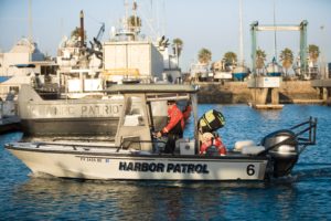 A harbor patrol boat cruises the harbor, early in the morning