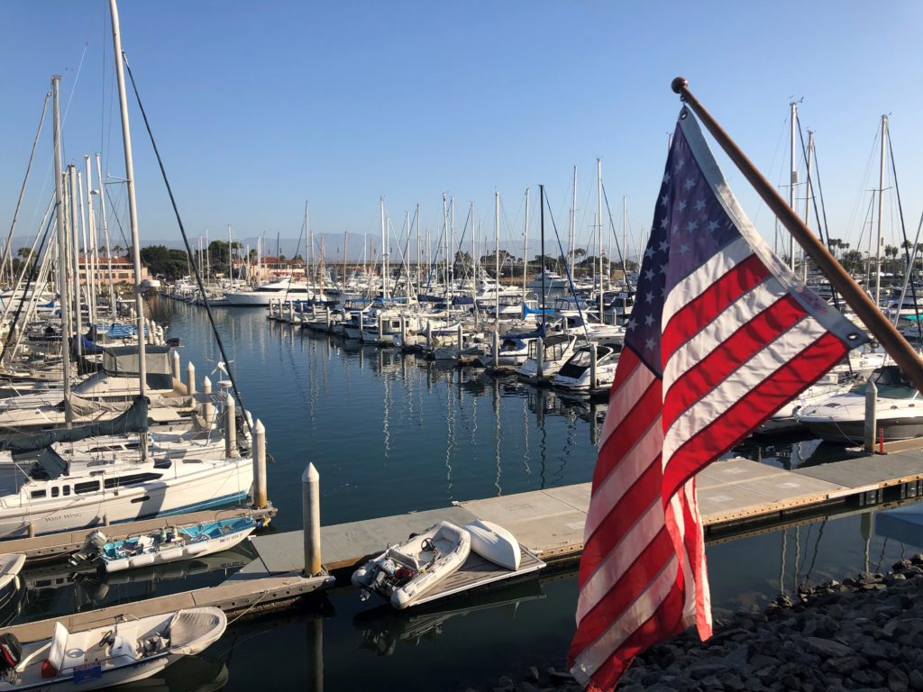 An American flag is pictured, harbor in the background