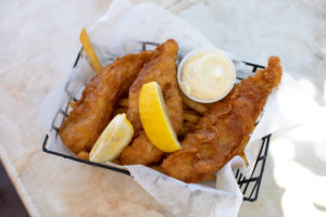 A fresh basket of fish and chips, w/ lemon wedges and tarter sauce