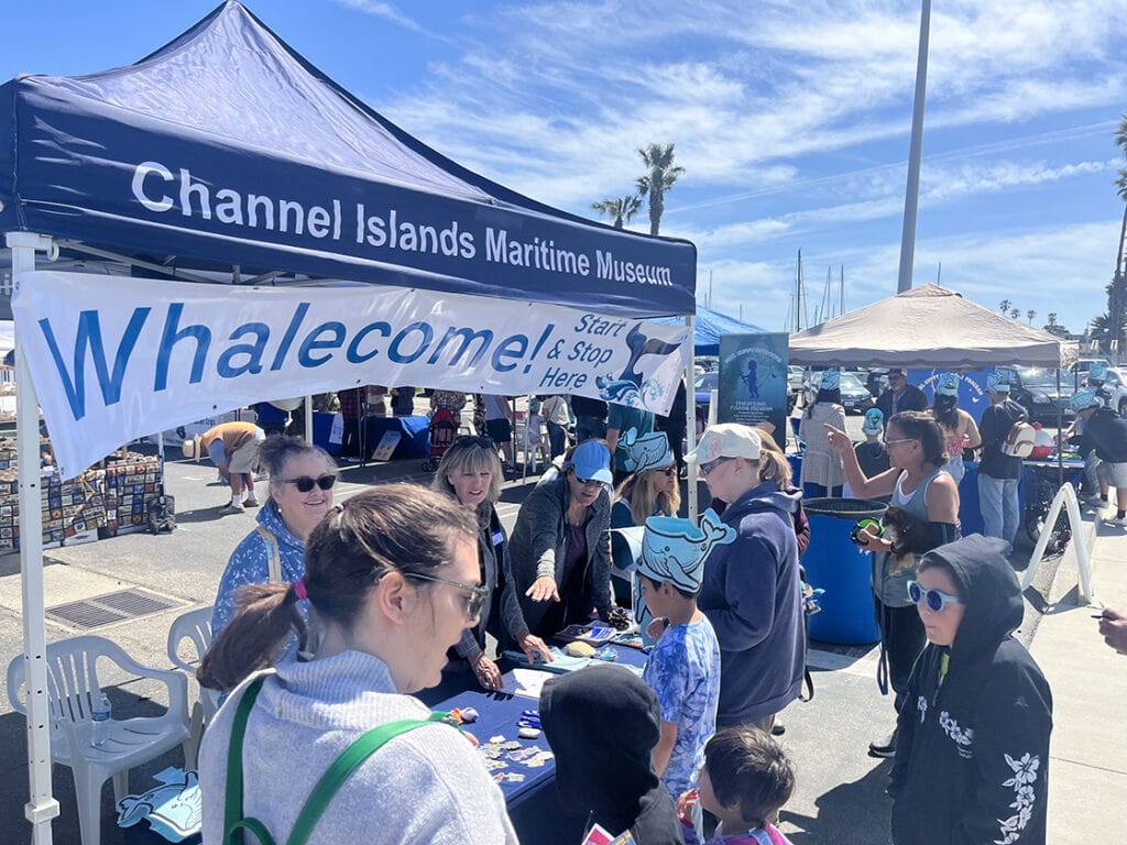 People gathering at Channel Islands Maritime Museum booth during Whales Festival.