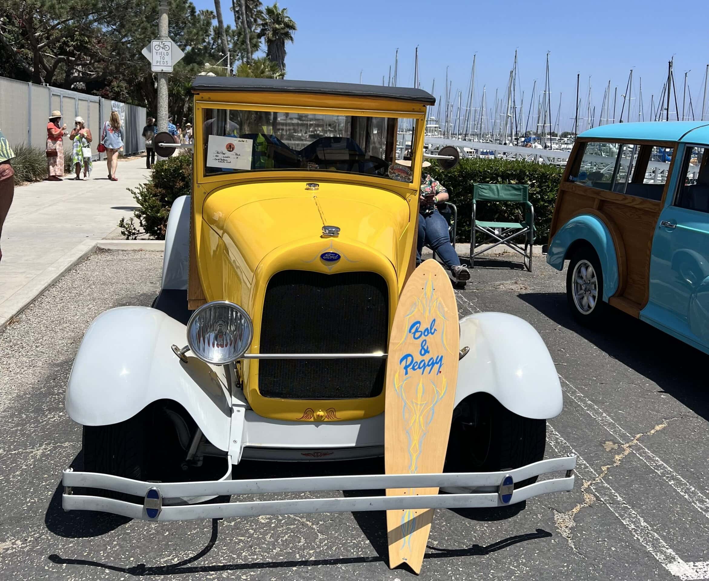 Vintage yellow and white classic car with surfboard at Channel Islands Harbor.