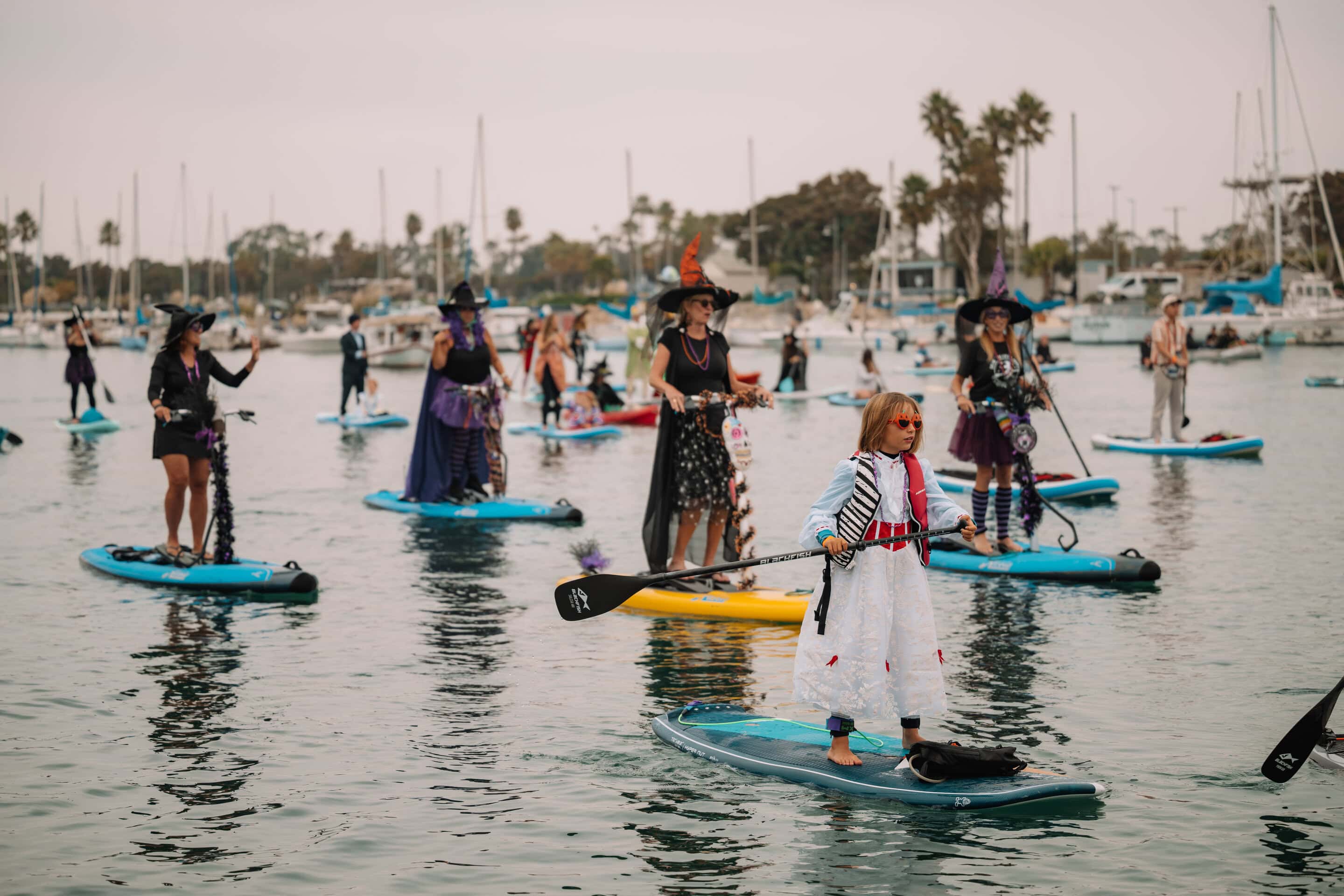 Children dressed as witches paddleboards during the Pumpkin Paddle event at Channel Islands Harbor.